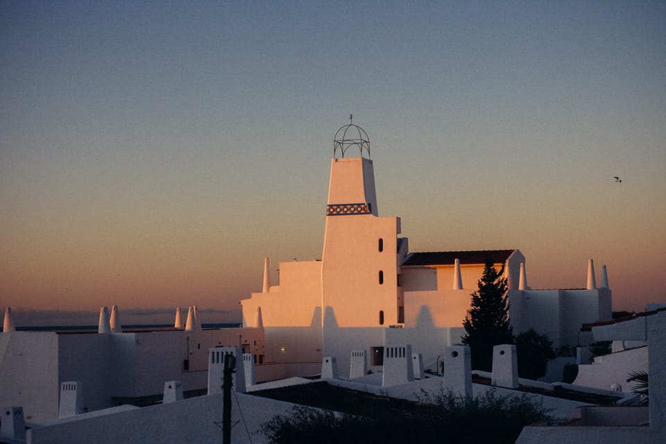 white buildings in portugal lit by the sunset. by leonie wise
