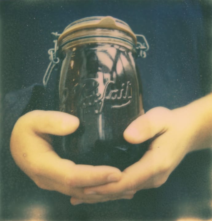 polaroid of hands holding a kilner jar containing cold brew coffee. copyright leonie wise